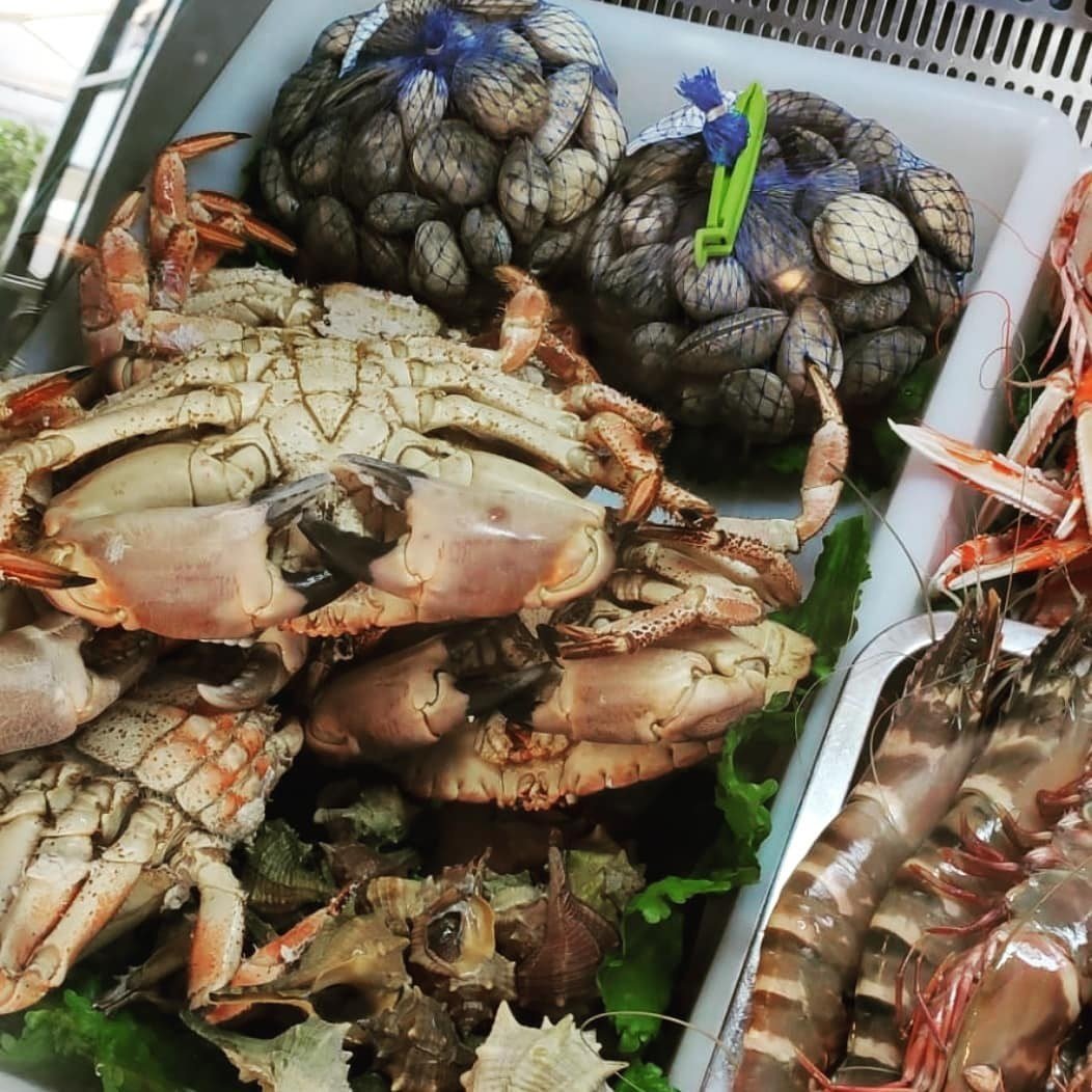 Montra de marisco com sapateiras, redes de amêijoas e camarão